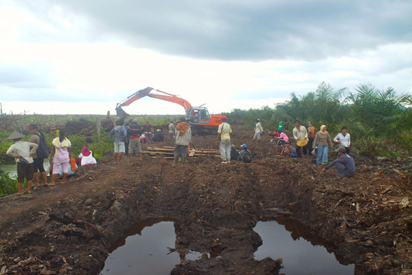 Aksi warga mengambil alih alat berat perusahaan dan merusak jembatan pembatas pada 2012. Foto: dokumen Serikat Tani Kubu Raya