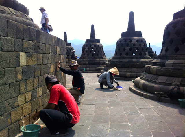 Sejumlah petugas terlihat membersihkan candi dari pasir dan sampah yang ditinggalkan pengunjung.Foto: Nuswantoro