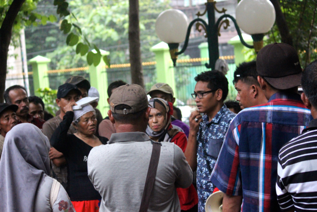 Warga Batu di bawah rintik hujan usai ke DPR, mereka sedang mendengar penjelasan dari Ony Mahardika, Direktur Eksekutif Walhi Jatim (memegang pengeras suara). Foto: Sapariah Saturi