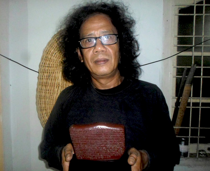 Dodi Suwandi menunjukkan miniatur Prasasti Talang Tuwo yang dibuatnya. Sebuah upaya membangun spirit Sriwijaya untuk menjaga lingkungan. Foto: Taufik Wijaya
