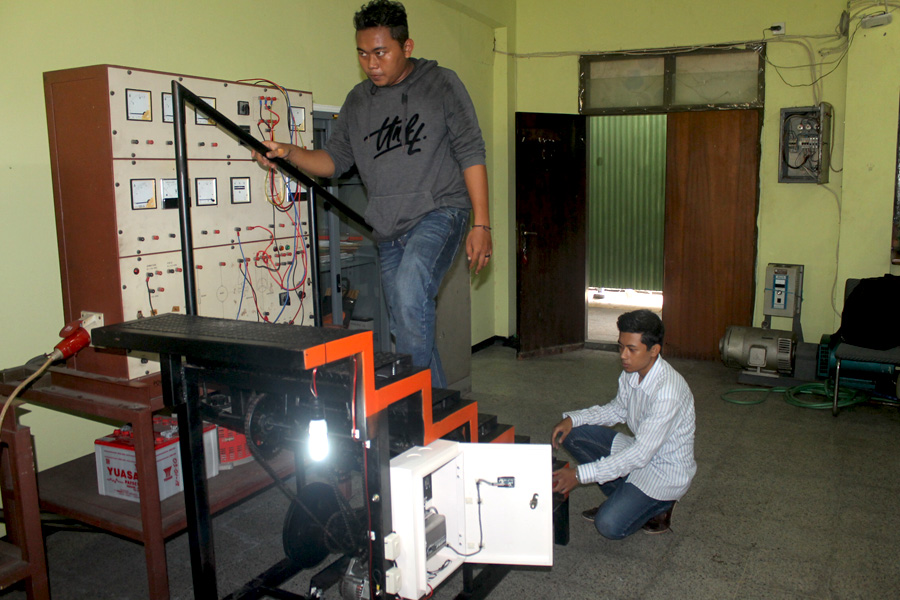 Saiful dan Raditiyo mendemonstrasikan tangga statis penghasil energi listrik yang dibuat mereka. Foto: Petrus Riski