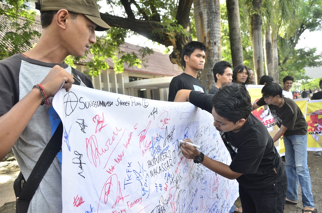 Warga Kota Makassar, Sulsel mendukung penolakan reklamasi Pantai Losari dengan membubuhkan tanda tangan spanduk putih yang dibentangkan Walhi Sulsel di Anjungan Pantai Losari, memanfaatkan acara Car Free Day, pada Minggu (07/02/2016). Foto : Wahyu Chandra