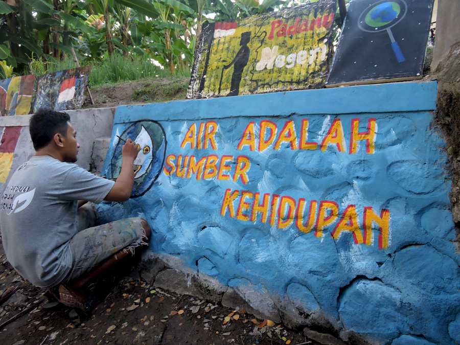 Seniman Gorontalo melukis mural pada beton saluran air atau parit. Foto: Christopel Paino