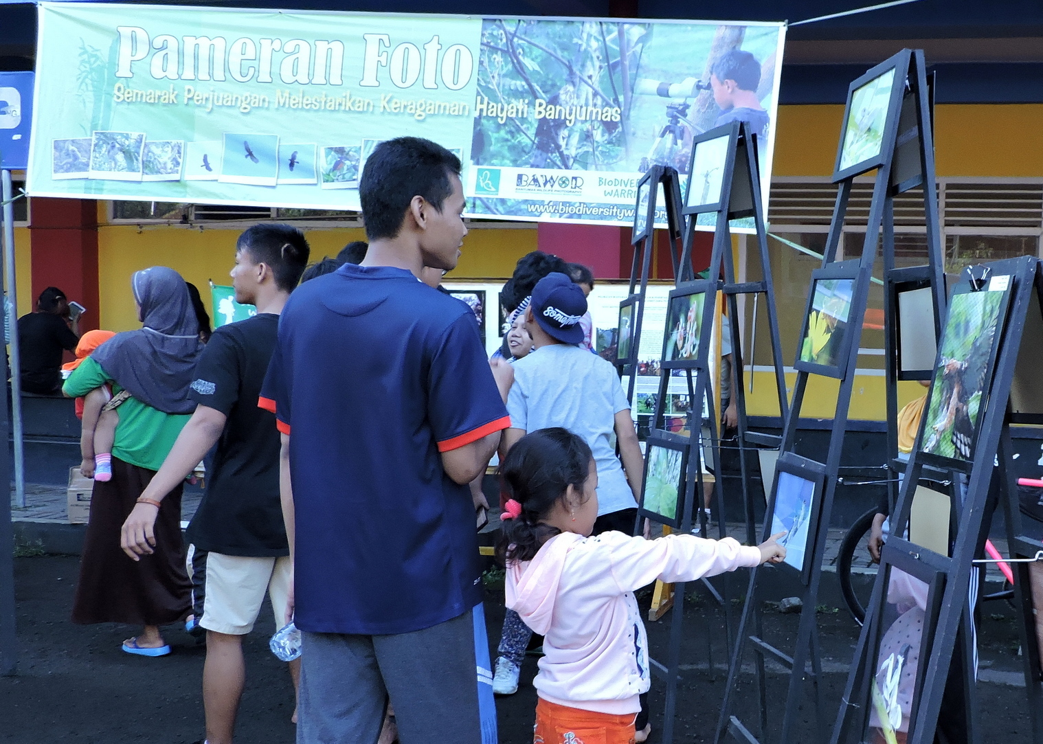 Pengunjung sedang melihat-lihat koleksi foto satwaliar yang dipamerkan oleh Banyumas Wildlife Photografi (Bawor) di GOR Satria, Purwokerto Minggu (27/03/2016)