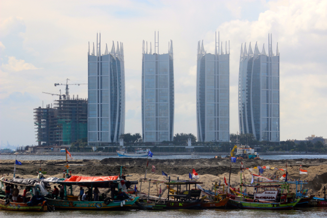 Tampak urukan pasir di Pulau G, dengan latar belakang gedung di Kota Jakarta. Foto: Sapariah Saturi