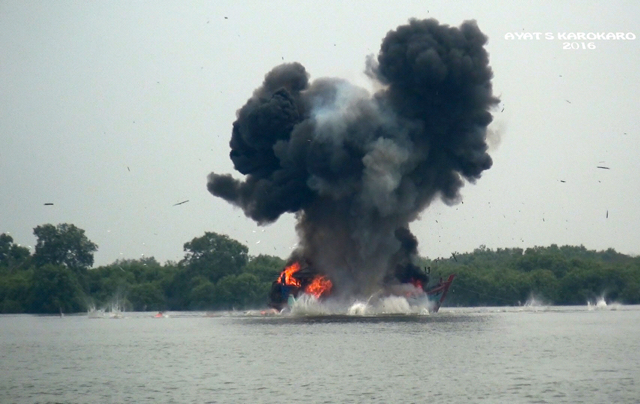 Asap tebal membumbung di laut Belawan, saat tim Polair Polda Sumut meledakkan kapal berbendera Malaysia yang mencuri ikan di Perairan Indonesia. Foto: Ayat S Karokaro