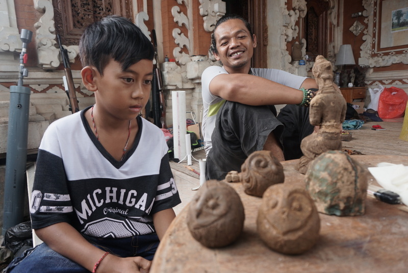 Seorang anak Dusun Pagi, Tabanan, Bali dengan patung burung hantu. Petani Dusun Pagi menggunakan burung hantu sebagai predator alami untuk mengatasi hama tikus di sawahnya. Foto : Luh De Suriyani