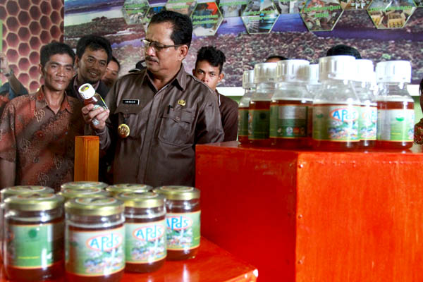 Bupati Kapuas Hulu, AM Nasir mengamati madu hutan dalam kemasan, seiring peresmian penggunaan Rumah Workshop Madu Hutan di Dusun Semangit, Desa Nanga Leboyan, Kecamatan Selimbau. Foto: Dok. Asosiasi Periau Danau Sentarum