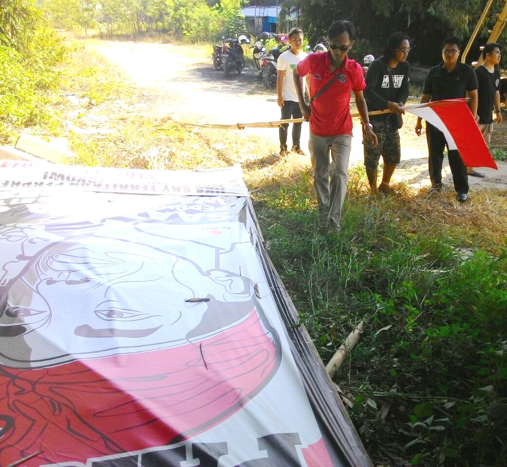 Baliho yang dirobohkan tentar, berisi sambutan kedatangan Presiden jokowi di Bali sekaligus meminta untuk pencabutan Perpres tentang reklamasi Teluk Benoa Bali. Foto : ForBALI