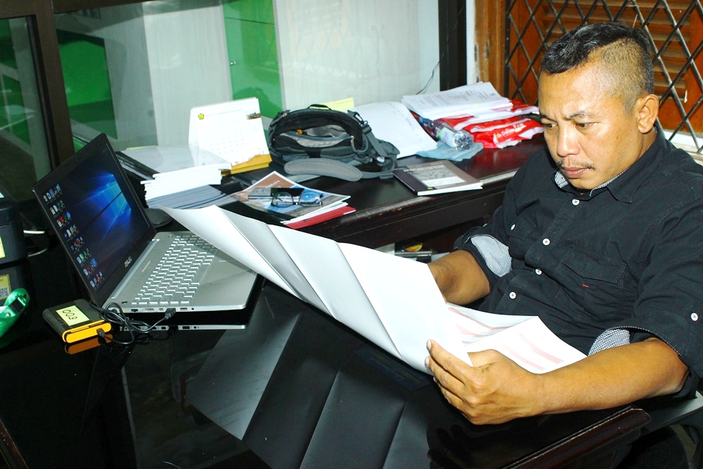 Erick salah satu peneliti geologi sedang membaca peta lokasi ditemukan fosil mata mange hasil ekskavasi di Cekungan Soa, Flores, Nusa Tenggara Timur. Foto : Donny Iqbal