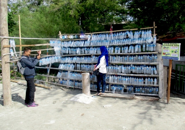 Sepasang pengunjung berfoto di depan Pondok Sandal Jodoh, di Pantai Tapak Paderi, Kelurahan Pondok Besi, Kota Bengkulu. Pondok sandal Jodoh merupakan sarana pengolahan sampah menjadi bentuk yang menarik dan aktraktif. Foto : Dedek Hendry