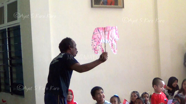 Kala mendongeng, dia membawa alat peraga, dari kertas yang dibentuk menjadi beragam satwa, seperti harimau, gajah, badak dan orangutan. Foto: Ayat S Karokaro