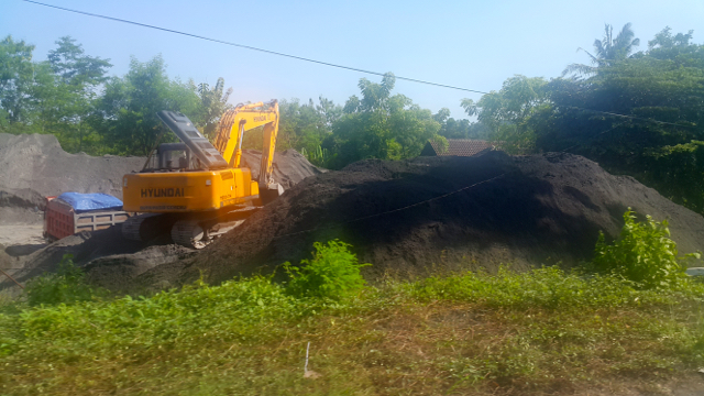Alat berat tampak bekerja, mengeruk pasir besi di pesisir. Foto: Tommy Apriando