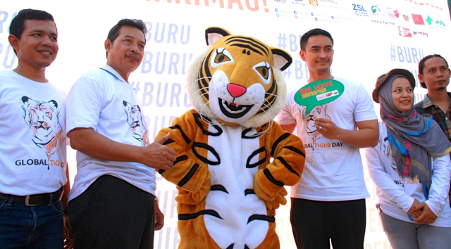 Zumi Zola (memegang poster hijau), kala ikut peringatan Hari Harimau Dunia di Jambi. Foto: Lili Rambe