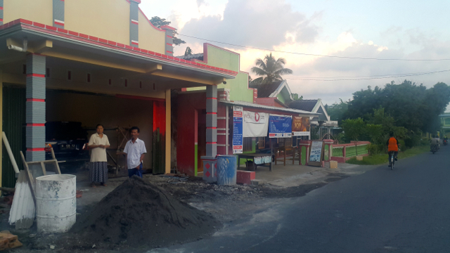 Rumah Tosan, yang berada di pinggir jalan desa, setiap hari dilewati truk pengangkut pasir besi. Foto: Tommy Apriando 