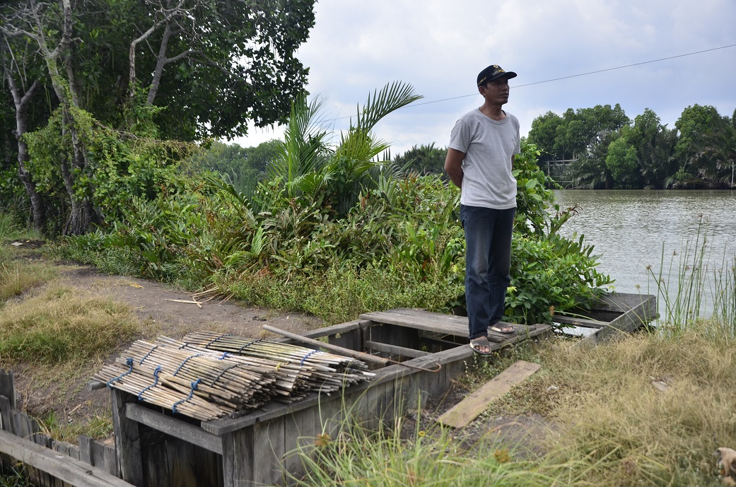 Pintu air yang menghubungkan sungai Tallo dan tambak. Meski kondisi sungai tercemari, para petambak di Pulau Lakkang masih bisa panen dengan cara mensiasati aliran air yang masuk ke tambak. Ketika air sungai berwarna hitam dan bau segera dilakukan penutupan pintu air. Foto: Wahyu Chandra