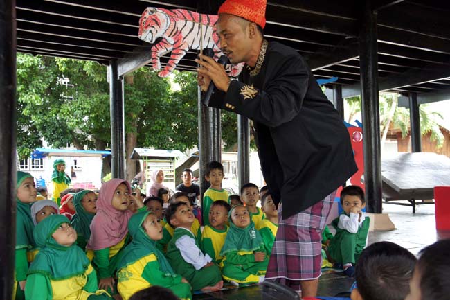 Samsudin mendongeng tentang satwa untuk anak-anak TK di Museum Aceh. Foto: Chik Rini