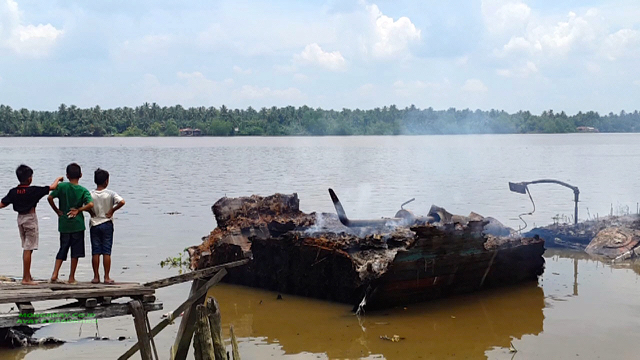 Anak-anak melihat puing kapal pukat harimau yang dibakar nelayan . Foto: Ayat S Karokaro