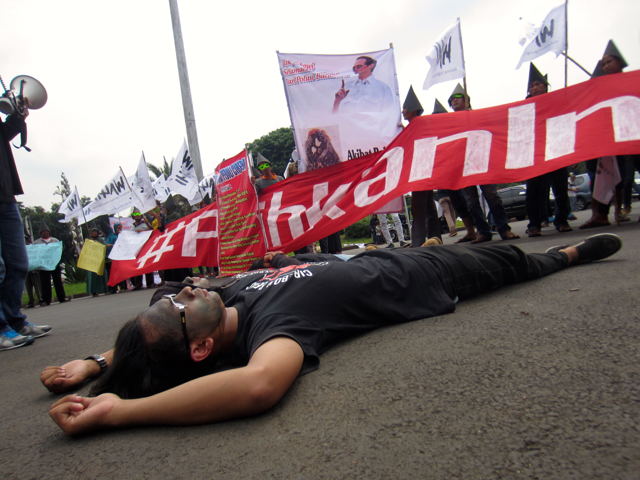 Warga aksi teatrikal memperlihatkan wajah hitam dan tubuh mereka kotor karena debu batubara. Foto: Della Syahni