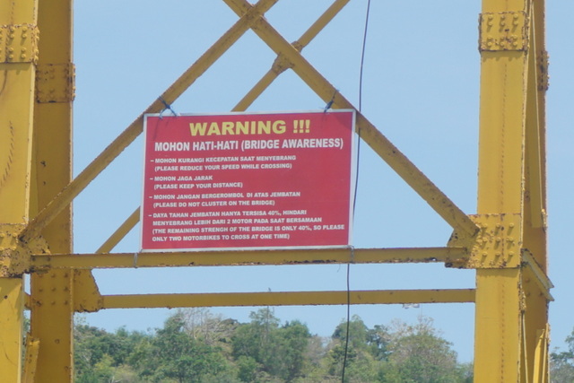 Papan plat imbauan yang sulit terbaca karena diletakkan sangat tinggi di atas jembatan yang menghubungkan Lembongan dan Nusa Centingan, Nusa Penida, Bali. Foto: Luh De Suriyani