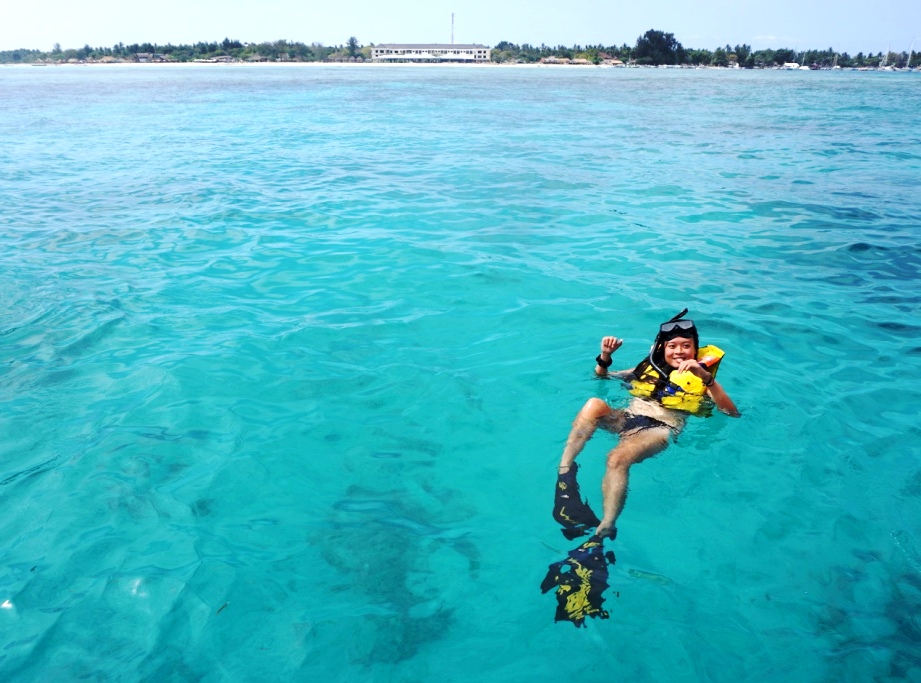 Seorang wisatawan melakukan snorkeling-dengan latar belakang hotel yang baru-dibangun di Gili Meno, NTB. Foto : Anton Muhajir