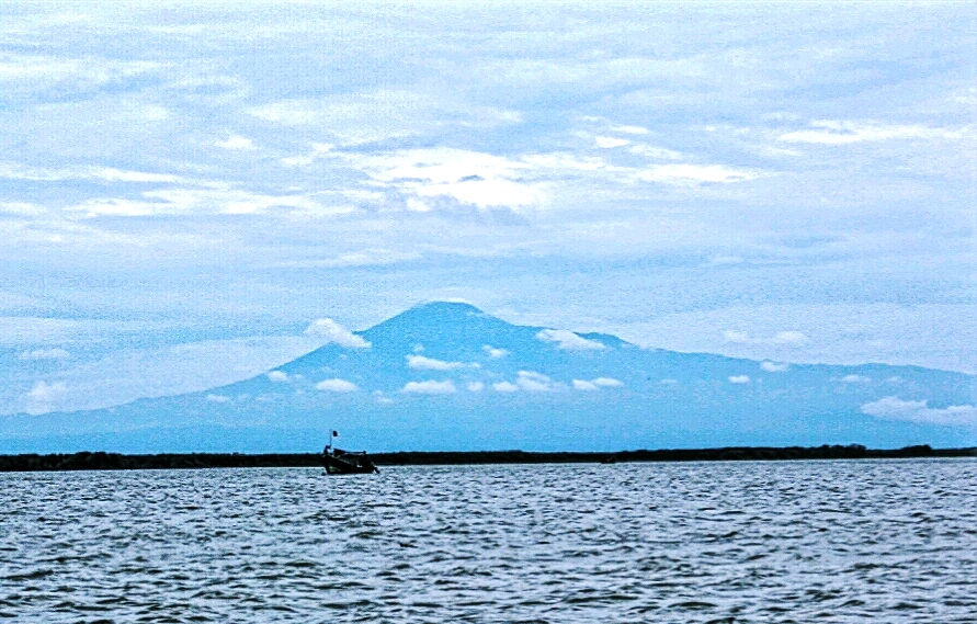Sebuah perahu di perairan Brebes, Jawa Tengah dengan latar belakang Gunung Slamet. foto : Donny Iqbal