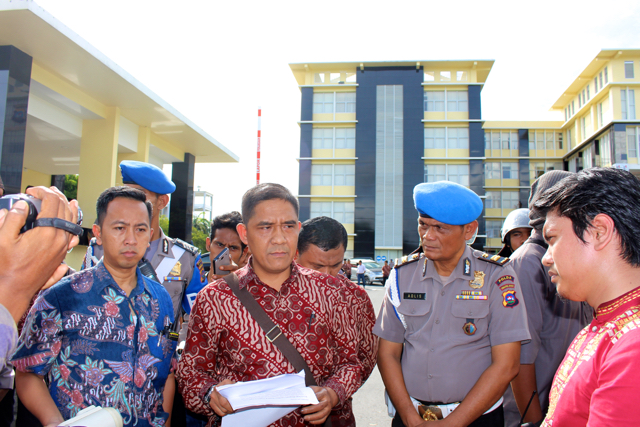 LBH Padang, Aulia Rizal menyerahkan berkas laporan hasil investigasi kepada Wakil Dir eskrimsus Polda Sumbar Dodi Rahmawan. Foto: Vinolia