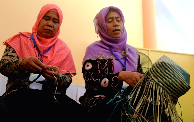 Salasiah bersama rekannya mengajarkan teknik menganyam purun pada beberapa pengunjung. Foto: Elviza Diana