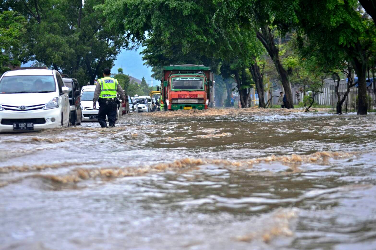 Kendaraan menerobos genangan air akibat meluapnya Sungai Cikijing di kawasan industri di Desa Andir, Rancaekek, Kabupaten Bandung, Selasa (1/11/2016). Foto : Thody Badai