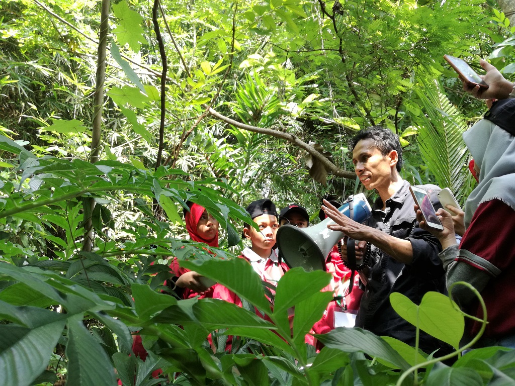 Para murid dari SD IKIP I Rappocini antusias mengikuti penjelasan tentang beragam tanamaan dari Dermawan Denassa di Rumah Hijau Denassa di Kelurahan Tamalayyang, Bontonompo, Gowa, Sulawesi Selatan. Mereka belajar langsung di lapangan, tidak hanya dari bacaan di pelajaran sekolah. Foto: Wahyu Chandra.
