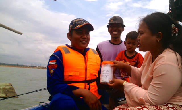 Junaenah menyerahkan surat harapan buat Presiden via Polisi Air. Sampakah? Foto: Greenpeace Idonesia