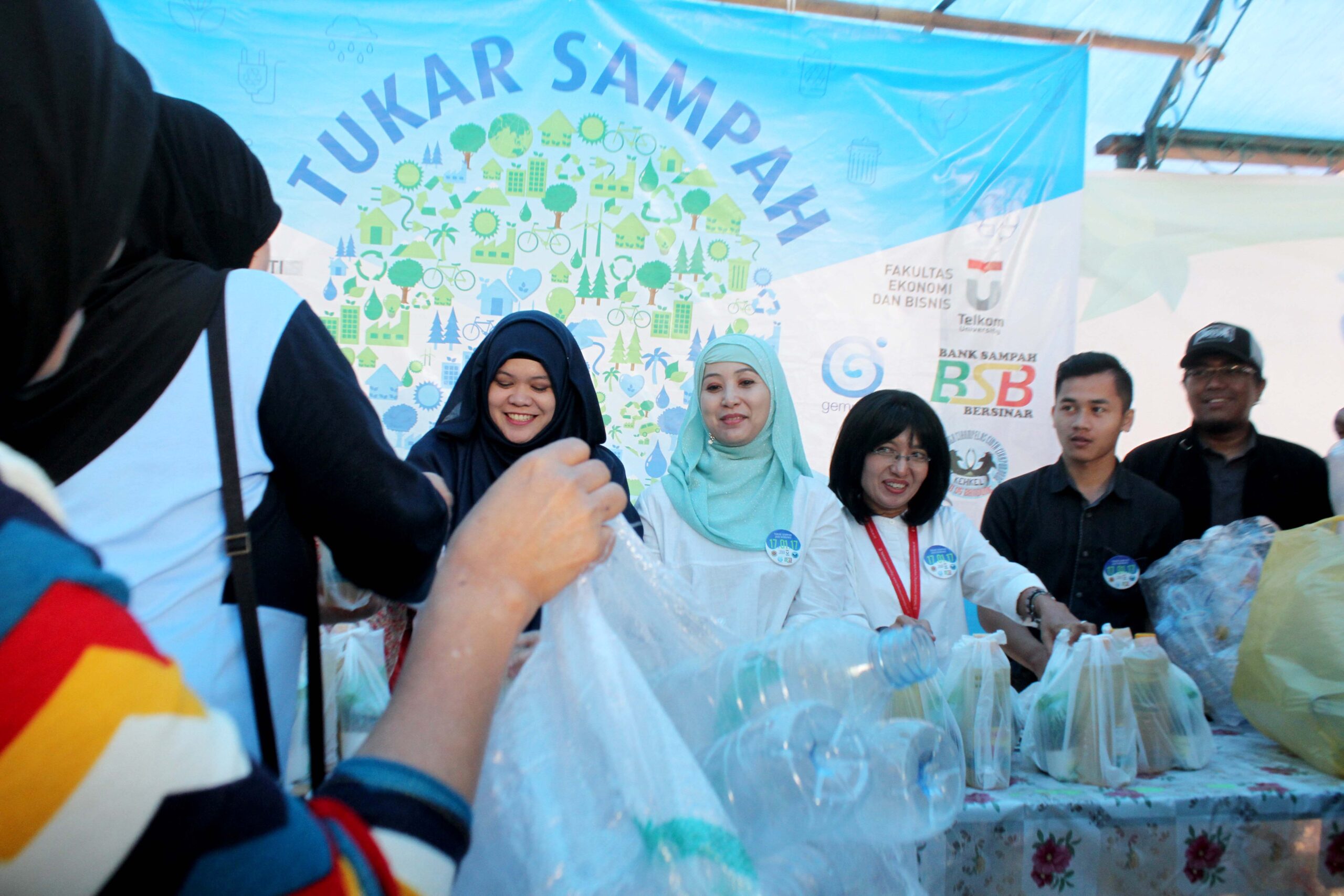 Warga menukarkan sampah botol bekas minuman dengan sembako kepada bank sampah di kelurahan Cipaganti, Kecamatan Coblong, Kota Bandung, Selasa (17/01/2017). Keberadaan bank sampah diharapkan dapat menumbuhkan kesadaran merawat lingkungan dengan cara memilah sampah menjadi berkah. Foto : Donny Iqbal 