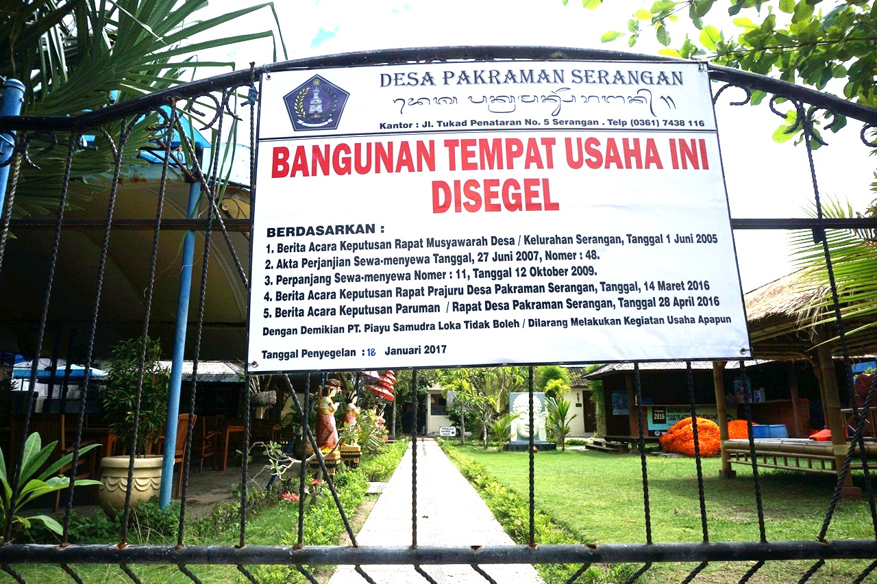 Sebuah spanduk dipasang desa pakraman Serangan di pintu masuk kantor Dolphin Lodge di pesisir pulau Serangan, Denpasar, Bali, yang disegel warga Desa Pakraman (adat) Serangan pada Rabu (18/1) sore, sebagai tanda disegel dan dilarang melakukan kegiatan usaha wisata lumba-lumba di darat dan perairan lokasi keramba apung si dolphin. Foto : Anton Muhajir