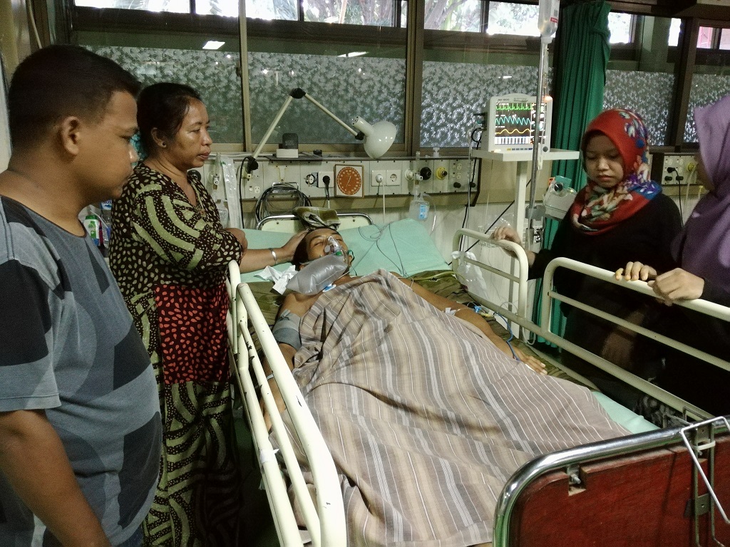 Saddam, nelayan korban penembakan yang diduga dilakukan oleh polisi hutan (jagawana) Taman Nasional Takabonerate, Selayar, Sulawesi Selatan, didampingi ibu dan anggota keluarganya masih terbaring lemah dengan bantuan oksigen, setelah menjalani operasi ketiga kalinya di RS Pelamonia Makassar. Foto : Wahyu Chandra