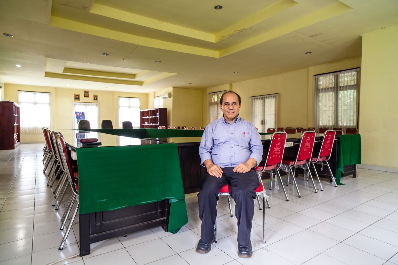 Agustinus Kastanya tengah berpose untuk difoto pada ruangan di mana rapat dengan Jacky pernah dilangsungkan. Foto oleh Leo Plunkett/The Gecko Project/Earthsight.