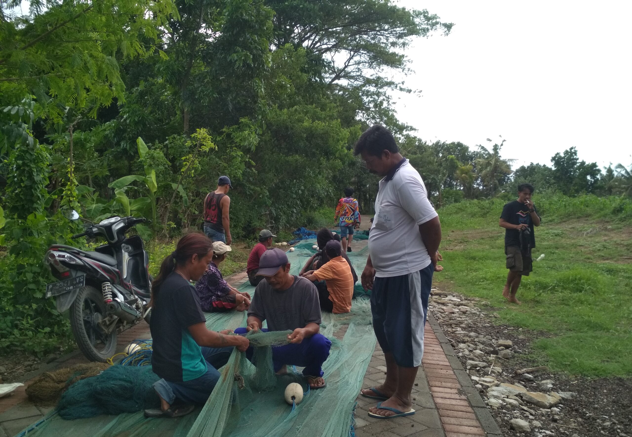 Nelayan yang tidak melaut memilih membenahi jala bersama-sama di samping tenda perjuangan sambil berjaga-jaga. Foto: RZ Hakim/ Mongabay Indonesia