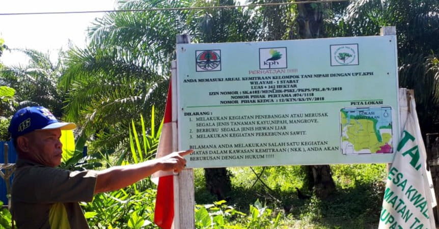 Samsul, Ketua Kelompok Tani Nipah, menumpuk plang yang berizi keterangan izin kelola kawasan hutan dari KLHK. Foto: Ayat S Karokaro/ Mongabay Indonesia