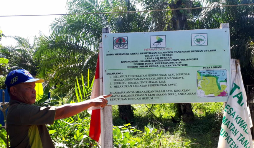Samsul, Ketua Kelompok Tani Nipah, menumpuk plang yang berizi keterangan izin kelola kawasan hutan dari KLHK. Foto: Ayat S Karokaro/ Mongabay Indonesia