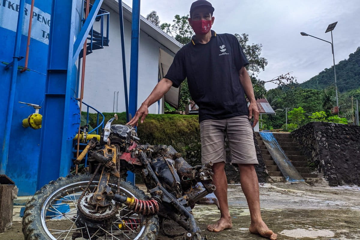 Wawan memperlihatkan motornya yang rusak. Foto: Agus Mawan/ Mongabay Indonesia