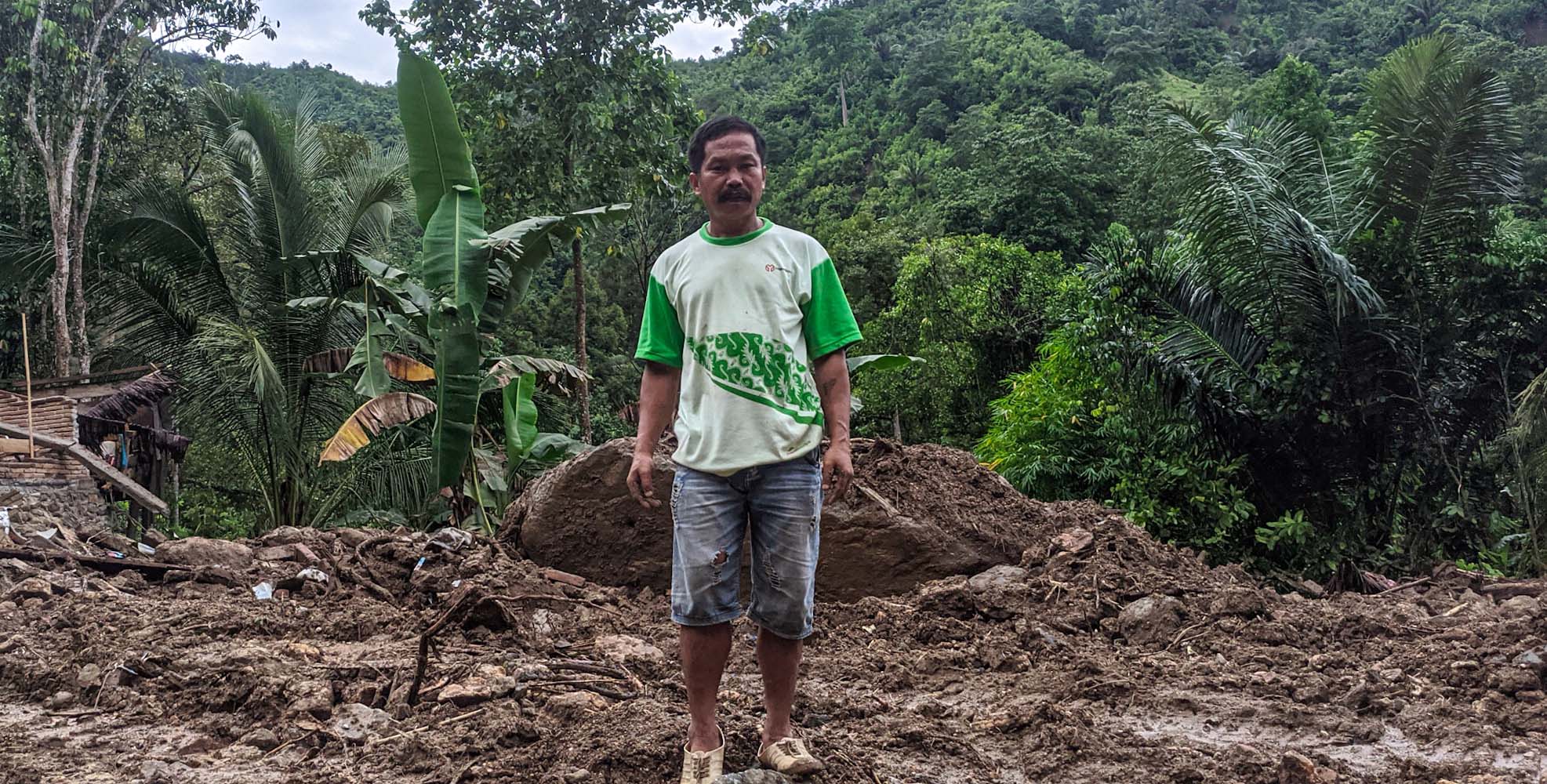 Kawaeu berdiri di tanah yang dulu lokasi rumahnya yang runtuh terlibas tanah longsor. Foto: Agus Mawan/ Mongabay Indonesia