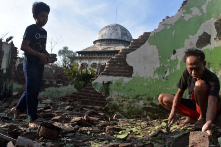 Maduri, salah satu warga korban lumpur Lapindo memilah batu bata di bekas bangunan SDN Besuki.