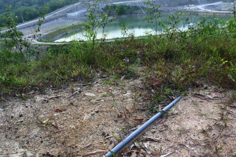 Pipa yang mengalirkan air dari bekas lubang tambang batubara ke rumah-rumah warga di Desa Sikalang. Fotto: Jaka HB/Mongabay Indonesia