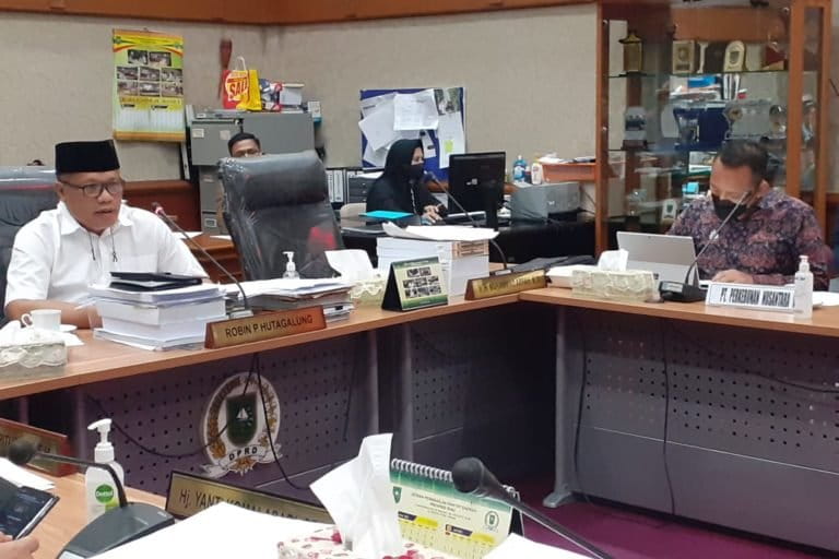 obin P Hutagalung pakai baju putih dan peci hitam, memimpin Rapat Dengar Pendapat (RDP) bahas konflik lahan antara PTPN V dengan masyarakat adat Pantai Raja untuk pertama kalinya. Foto: Suryadi