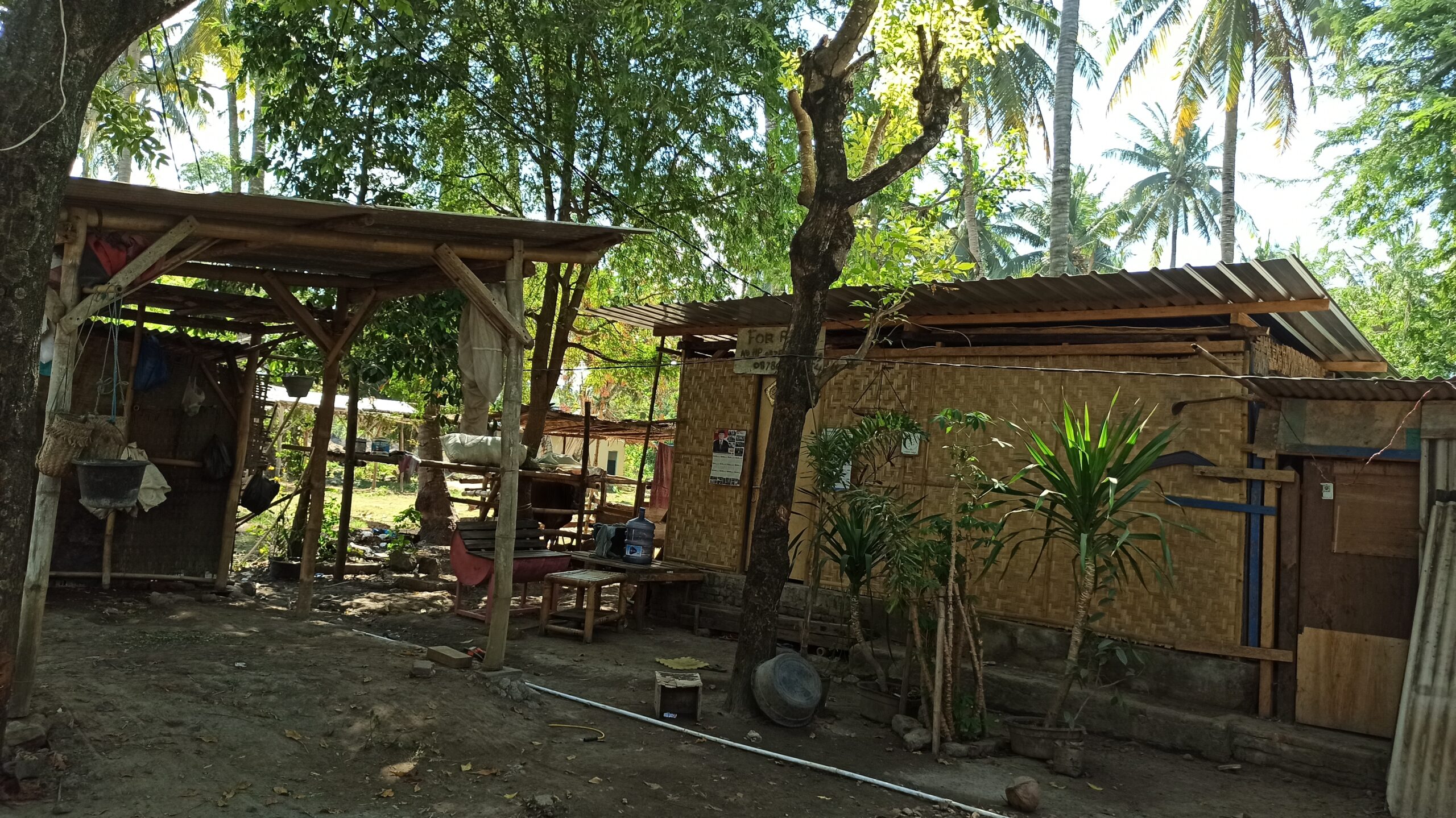 Rumah warga di Ebunut masih sangat sederhana, mereka bertahan karena merasa tidak pernah menjual tanah mereka. Di dinding-dinding rumah warga tertempel stiker dan poster calon kepala daerah dan politisi. Foto: Fathul Rakhman/Mongabay Indonesia