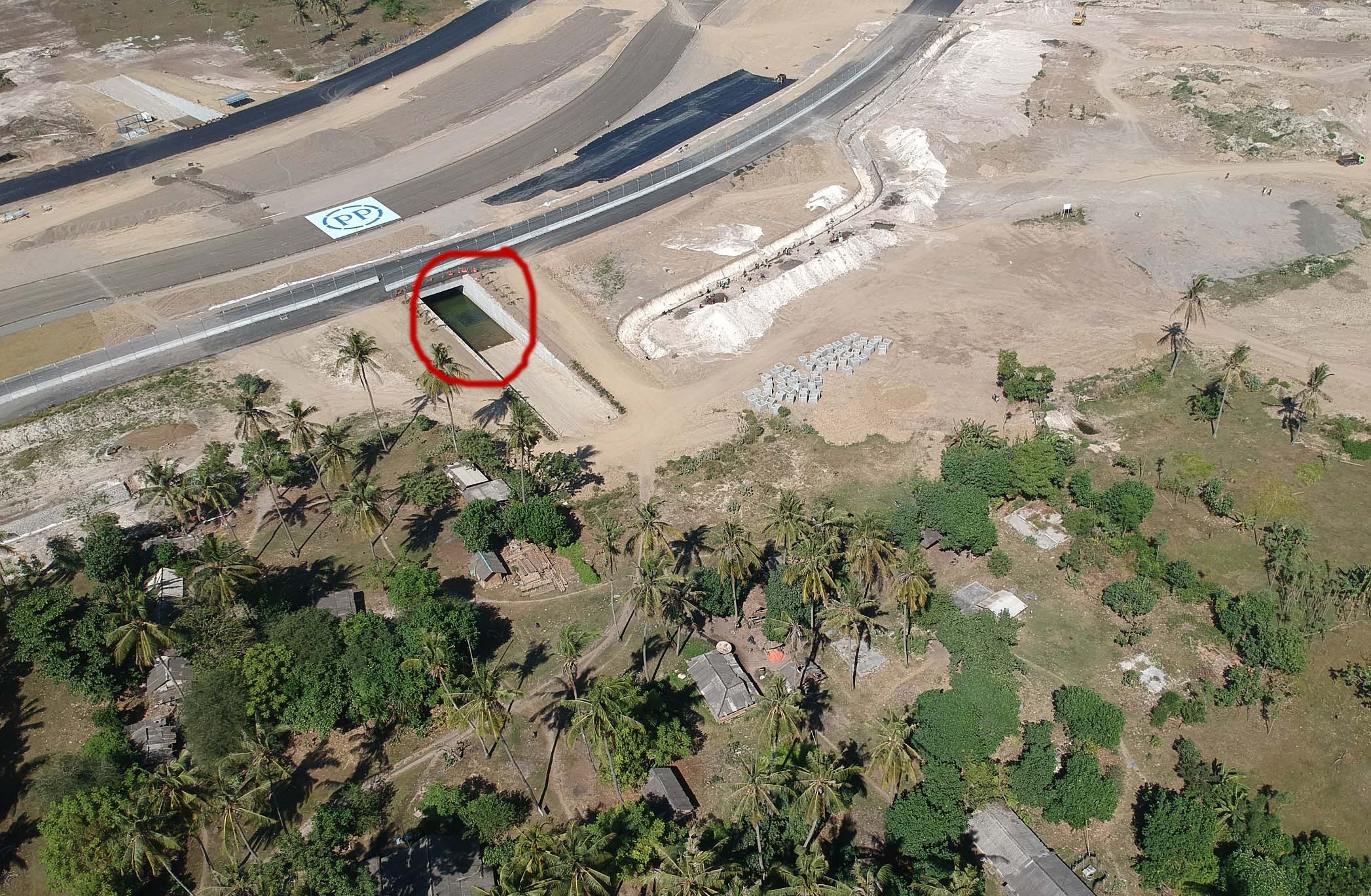 Tunnel (terowongan)—dengan lingkaran merah-- yang disiapkan sebagai akses pintu keluar masuk warga tampak penuh dengan tergenang air. Terpaksa warga menjebol pagar kawat sebagai pintu keluar masuk. Foto: Fathul Rakhman/Mongabay Indonesia