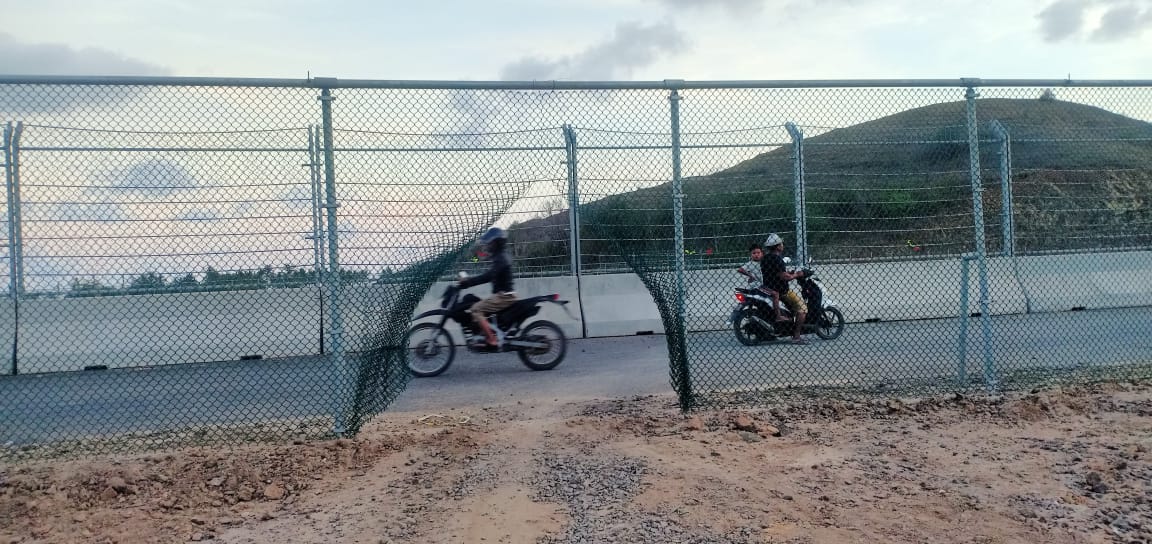 Warga terpaksa menjebol pagar pembatas lintasan sirkuit karena tidak ada akses keluar masuk kampung. Foto: Dedi/Mongabay Indonesia
