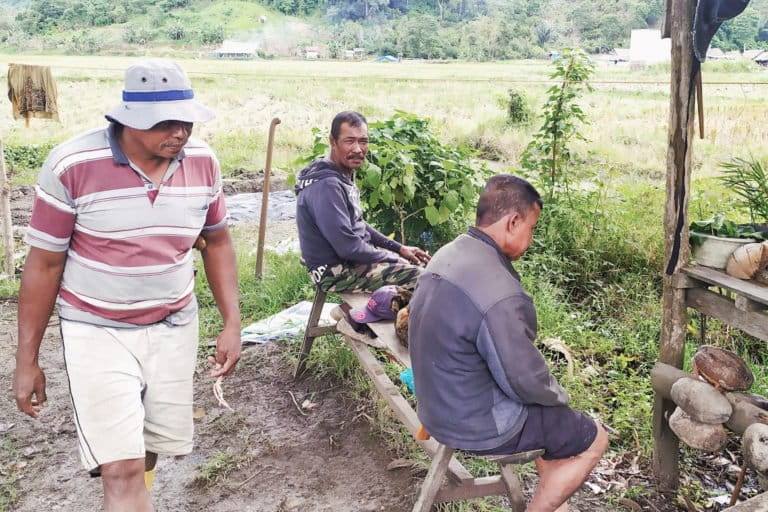 Ramli (bertopi), Lamiri (tengah) Sambi (kanan) sedang bersantai di tepi sawah. Foto: Agus Mawan/ Mongabay Indonesia 