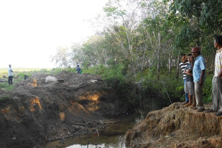 Warga di tepian parih besar bikinan perusahaan sawit Duta Palma. Foto: Suryadi/ Mongabay Indonesia