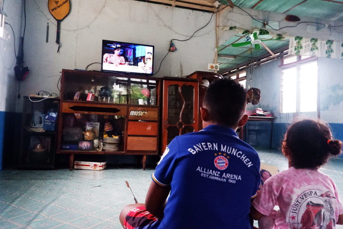 Kevin dan Aulia, tengah asik nonton televisi dari sumber energi surya. Foto: Yogi Eka Sahputra/ Mongabay Indonesia