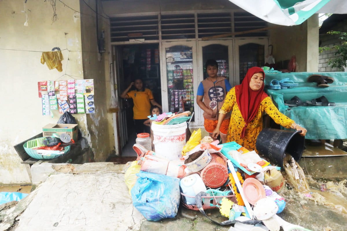 Ira, warga Jondul Rawang membersihkan rumahnya setelah terkena banjir. Foto: Jaka HB/ Mongabay Indonesia